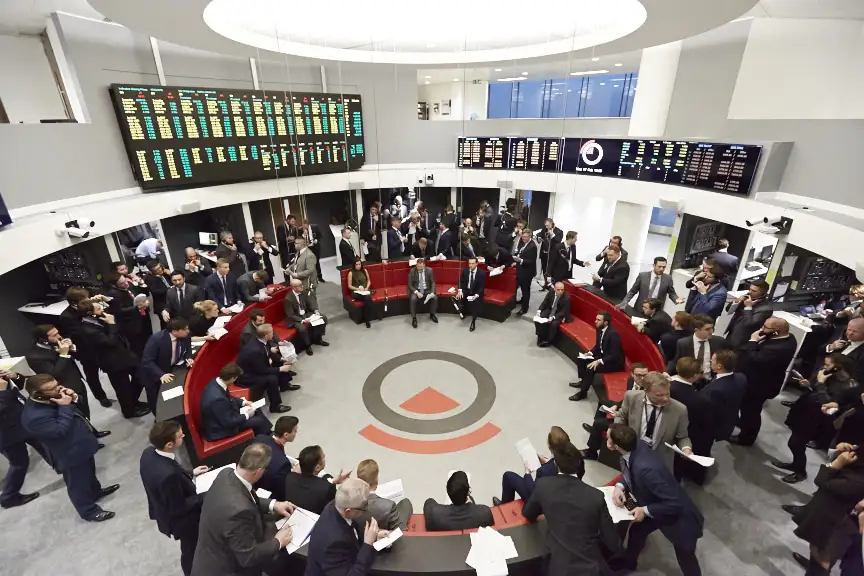 People seated in a circular conference room engaged in discussion.